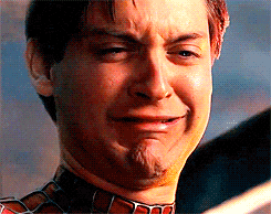 L'attore Tobey Maguire nei panni di Peter Parker, dal film Spider-Man, con il volto rigato dalle lacrime e un'espressione di profonda tristezza e disperazione